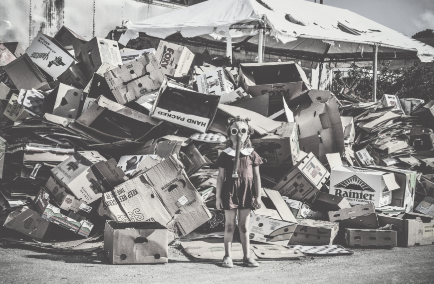 Imagen de distopía: niña con máscara entre basura